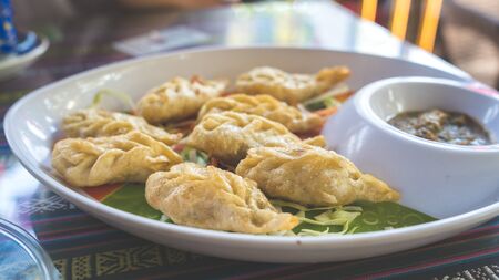 A dish of the tibetan fried momo with a sauce. Momo is a dish of dough with a fillingの写真素材