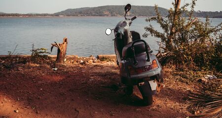 A scooter is parked on the coast of the sea or ocean