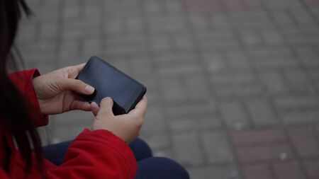 Women's hands holding the phone close up. Space for your textの写真素材