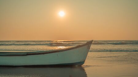 The old boat by the sea against the sunsetの写真素材