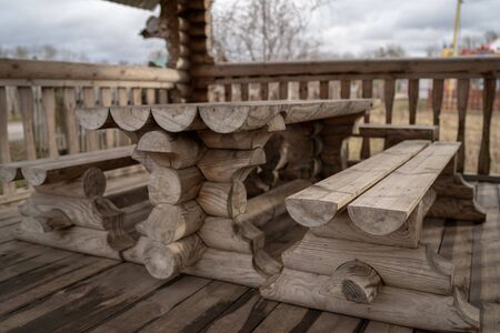 Fenced terrace with log table and benches in empty park during gloomy autumnal dayの写真素材