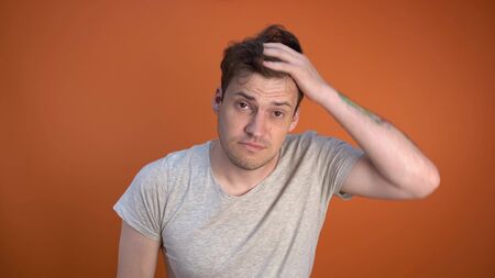 Sleepy man in the morning, combing his hair using a comb
