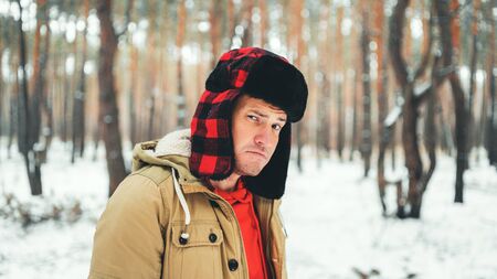 Handsome man standing in forest in winter season.の写真素材