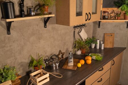 Modern domestic dark interior of kitchen cabinets and shelves with cookware.