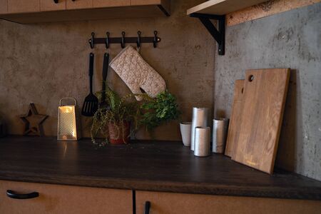Modern domestic dark interior of kitchen cabinets with cookware.