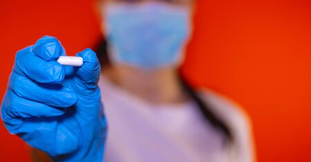 Pharmacist holding a pill. Female hand holding a white pillの写真素材