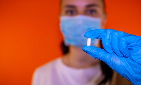 Pharmacist holding a pill. Female hand holding a white pillの写真素材