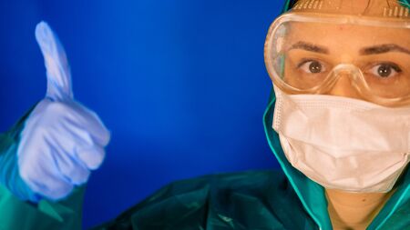 The concept of a coronavirus. Respiratory protection. A woman in a protective suit and a respiratorの写真素材