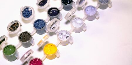 Multi-colored acrylic paints in jars on a white background. Jars with multicolored gouache isolated...