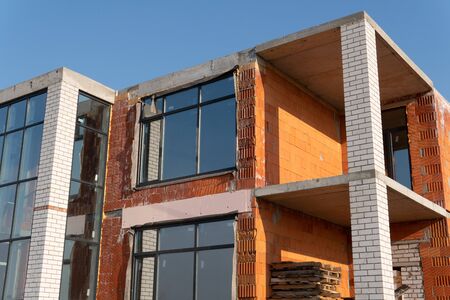 Close up of unfinished house in residential area. Modern architecture of construction brick house...