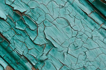 Textured background of old lumber surface with crumbling turquoise paint outside shabby buildingの写真素材