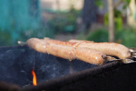 Close up of toasted sausages on skewers. Succulent kupaty roasting on chargrill.の写真素材