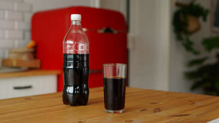 Transparent glass with cola on kitchen table.の写真素材
