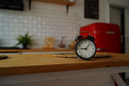 Black vintage clock on kitchen table.の写真素材