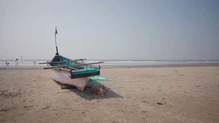 Large old white boat on sandy seaside ready to sail in bright day on beachの写真素材