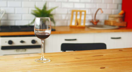 Close up of glass of wine on table in kitchen.