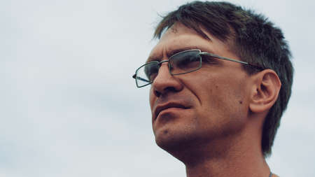 Close up of adult male on background of overcast sky.の写真素材