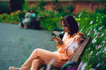 Adult female enjoying her rest with mobile phone on fresh air.の写真素材