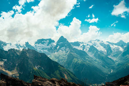 Mountain peaks against cloudy sky. Peaks of magnificent rocks located against bright cloudy sky on...
