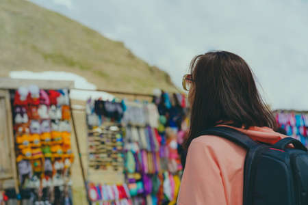 Woman tourist considering souvenirs in shopping booths.の写真素材