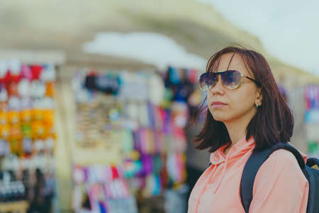 Woman tourist considering souvenirs in shopping booths.の写真素材