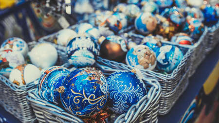 Set of wicker boxes with various traditional Christmas balls placed on stall in shopの写真素材