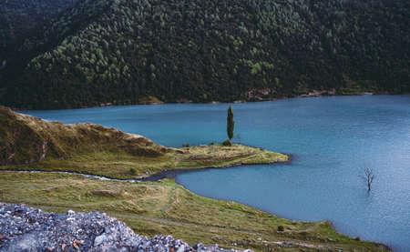 Picturesque river in green mountainous terrain. Spectacular scenery of calm river with turquoise water flowing among mountains covered with green forest.の写真素材