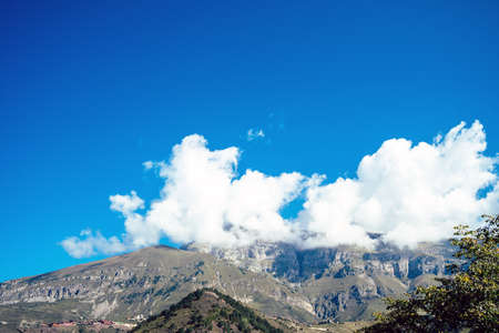 Picturesque scenery. Mountain against cloudy sky. Clouds floating on blue sky over mountain ridge