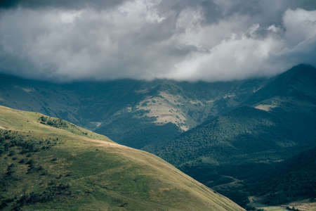 Mountain peaks against cloudy sky. Peaks of magnificent rocks located against bright cloudy sky.