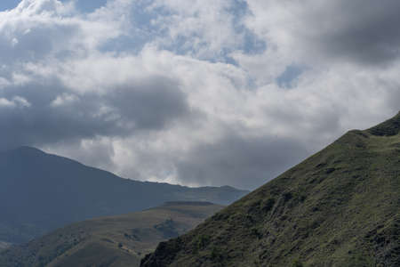 Mountain peaks against cloudy sky. Peaks of magnificent rocks located against bright cloudy sky.