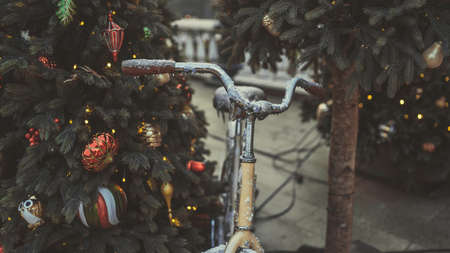 Close up of part of Christmas tree with different christmas toys and garland on street in evening city. Coniferous tree with decorative decorations to create festive mood.の写真素材