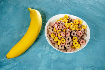 Banana and ripe fresh Juicy organic cherry tomatoes on a yellow plate. Red cherry tomatoes and...