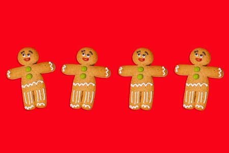 Close up of gingerbread men on red background. Festive decorative gingerbreads for Christmas mood...