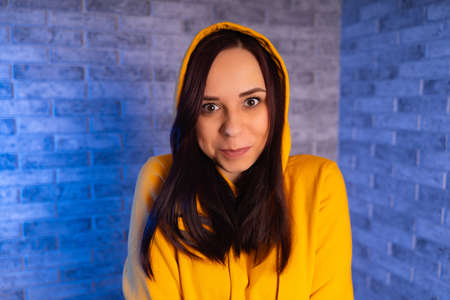 A young woman in a fashionable yellow hoodie. Portrait of a beautiful woman in a yellow hoodie...