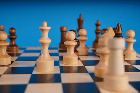 Close-up of chess on a blue background. Wooden chess pieces. Concept: the Board game and the...