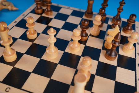 Close-up of chess on a blue background. Wooden chess pieces. Concept: the Board game and the intellectual activities.の写真素材