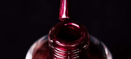 Close up of nail polish on black background. Maroon brilliant lacquer for manicureの写真素材