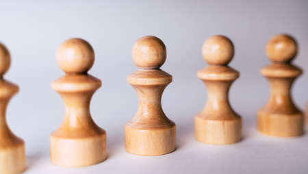 Close up of white wooden chess pieces. Row of white pawns on white backgroundの写真素材