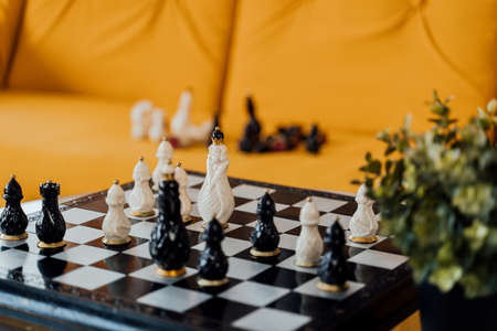 Close up of beautiful chess on table in room. Selective focus of porcelain chess pieces on chessboardの写真素材
