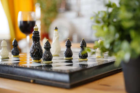 Close up of beautiful chess on table in kitchen. Selective focus of porcelain chess pieces on chessboardの写真素材