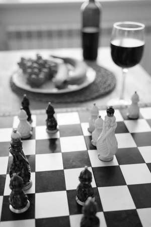 Close up of beautiful chess on table in kitchen. Selective focus of porcelain chess pieces on chessboardの写真素材