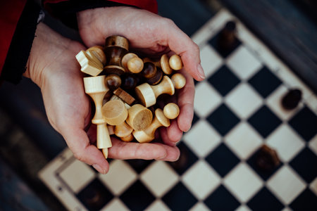 Close up of chess pieces in hands of unrecognizable woman. Unknown female holds figures of chess in her handsの写真素材