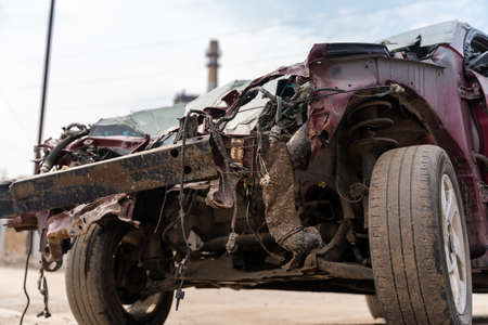 Close up of broken and abandoned car. Smashed car to pieces after accident on street. Concept of careless drivingの写真素材