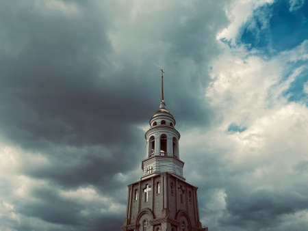 Bell tower of the cathedral of Christ. The bell tower of a Christian church on the background of a cloudy sky.の写真素材
