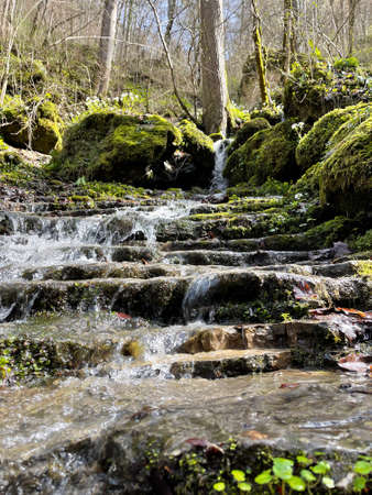 Beautiful landscape of mountain stream flowing down stone steps. Mountain waterway flowing down natural stairs in picturesque placeの写真素材