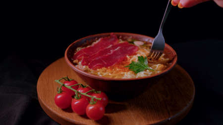 Close up of ready-made instant noodles with cherry tomatoes and dried meat in plate on tray....