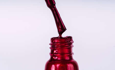 Close up of brilliant nail polish on isolated white background. Bright red lacquer for manicureの写真素材