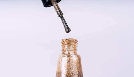 Close up of gold nail polish on isolated white background.の写真素材