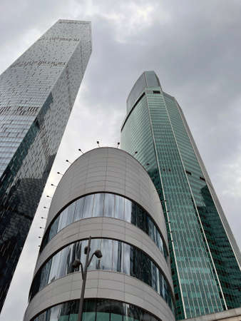 Facade of modern skyscraper with glass walls. From below of contemporary tall skyscraper with glass...