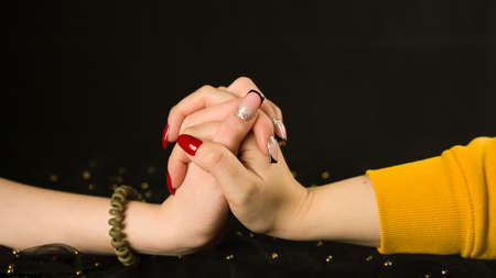 Crop girls hand and womans hand with different manicure. Unrecognizable females showing nail polish...